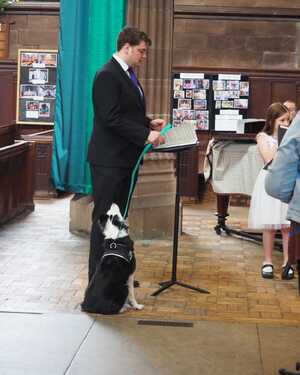 Dog with a man during a reading at St George's Church, Stockport